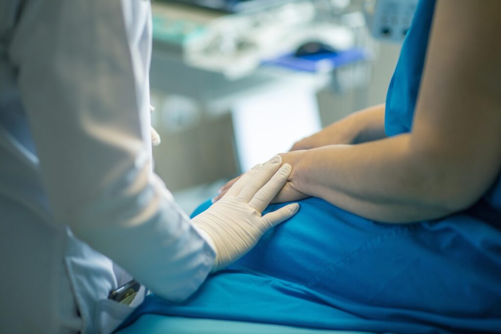 Healthcare professional providing compassionate care and reassurance to a patient during a medical visit.