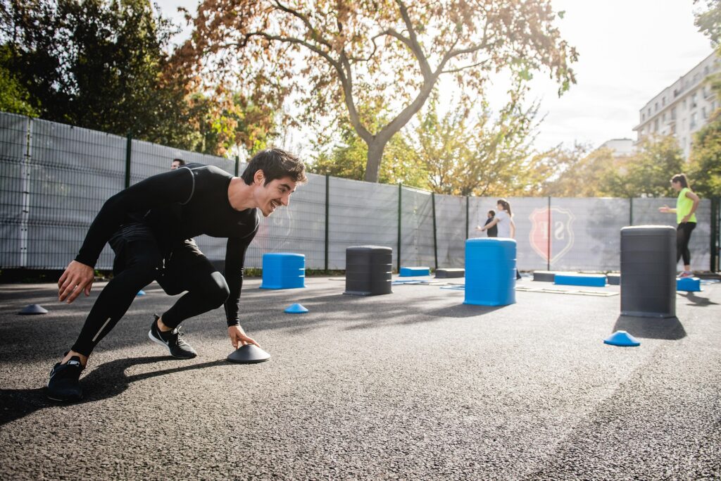 Person completing an outdoor fitness agility drill during an exercise training session.
