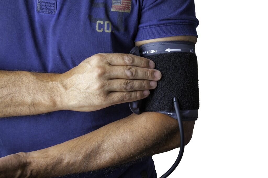 Person checking blood pressure with an upper arm blood pressure monitor during a routine health assessment.