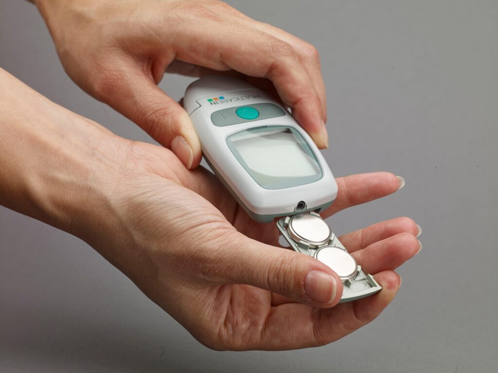 Person using a blood glucose meter to monitor blood sugar levels