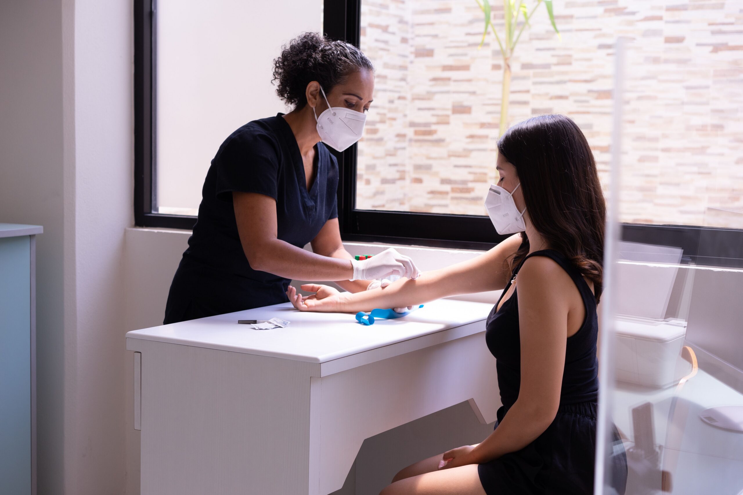 Healthcare provider drawing blood from a patient during a first internal medicine appointment.