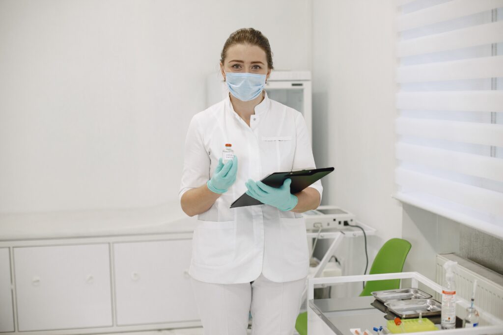 Medical provider holding an IV medication vial and reviewing a patient treatment plan.