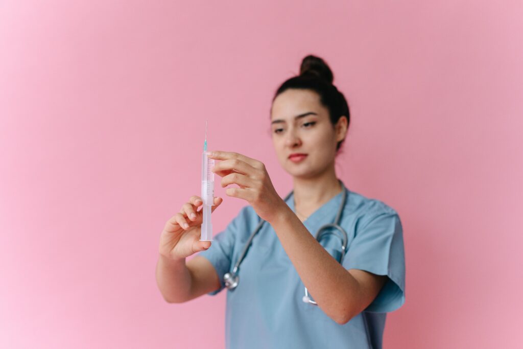 Medical professional preparing a syringe before administering IV therapy.