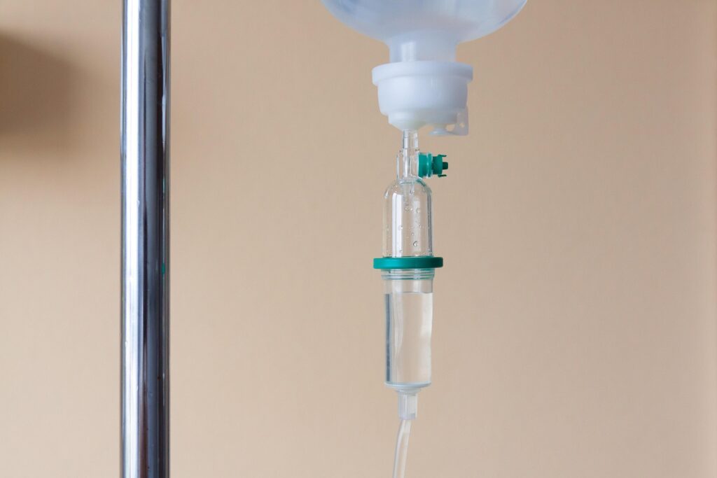 Close-up of an intravenous (IV) drip chamber used to administer fluids and medications in a hospital.