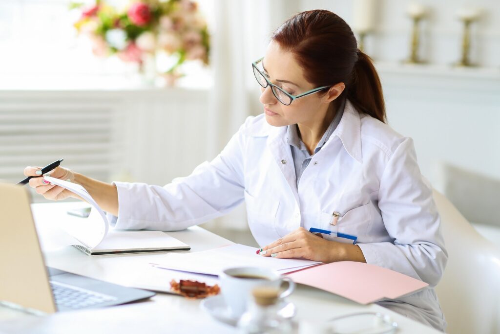 Internal medicine doctor reviewing patient records and preparing for a medical consultation.